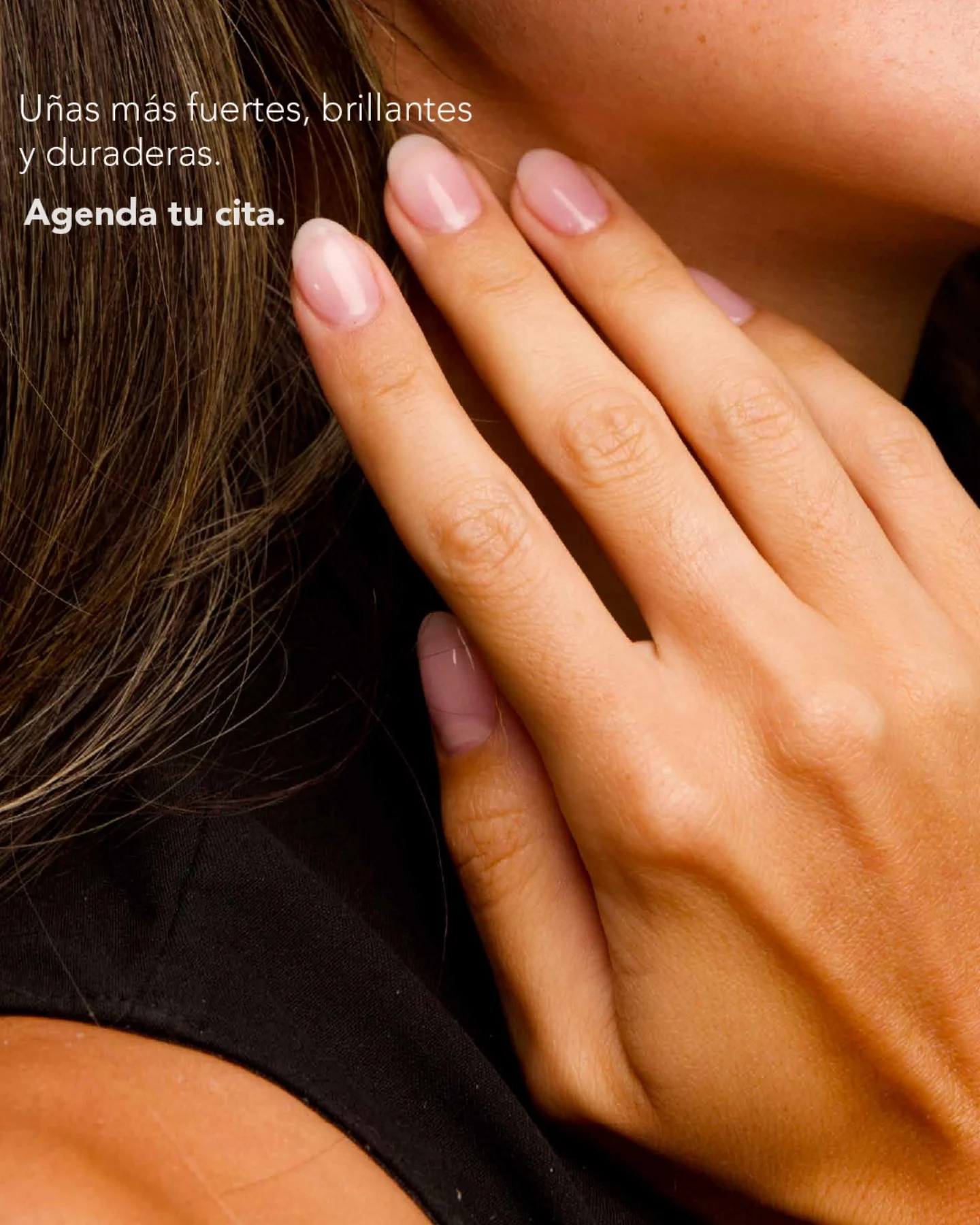 Mano con manicura natural apoyada sobre el cuello